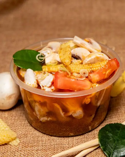 Bangcook – Soupe Tom Yum Poulet, un bouillon thaï épicé et parfumé à la citronnelle, garni de poulet et d’herbes fraîches