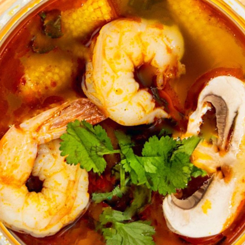 Bangcook resto Bol de soupe thaï Tom Yum fumante avec crevettes, citronnelle, galanga, combava et légumes frais.
