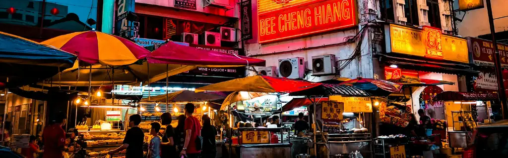 Stands de street food en Thaïlande de nuit, ambiance animée et éclairages chaleureux - Street food stands in Thailand by night, vibrant atmosphere with warm lighting